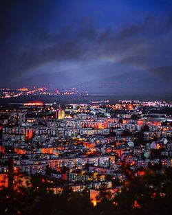 High angle view of illuminated cityscape against sky at dusk