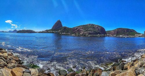 Scenic view of bay against blue sky