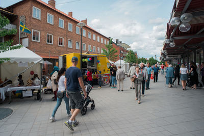 People walking on road against buildings