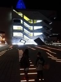 People in illuminated city at night