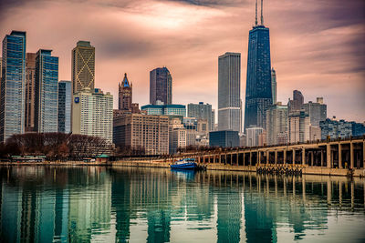 Modern buildings in city against sky during sunset