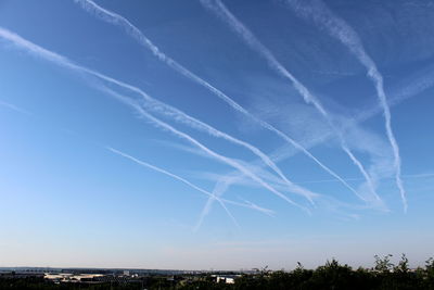 Vapor trails against blue sky