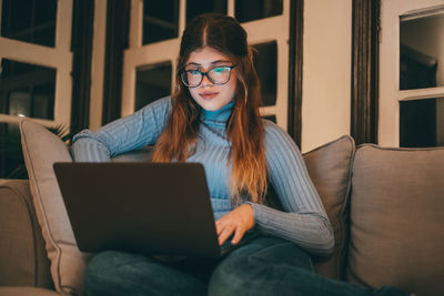 Young woman using laptop at home