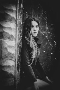 Portrait of young woman looking away while sitting outdoors