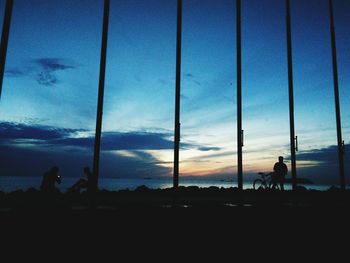 Silhouette people standing on land against sky during sunset