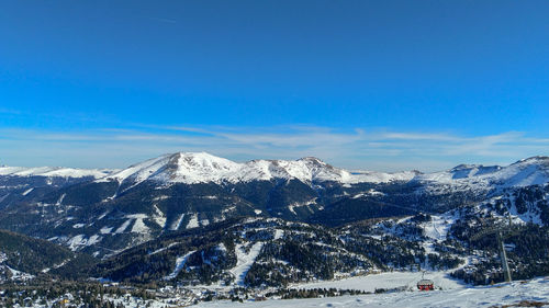 Scenic view of snowcapped mountains against blue sky