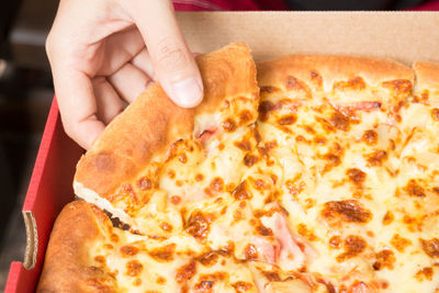 Cropped hand holding pizza