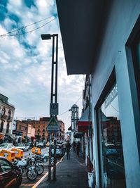 People on street in city against sky