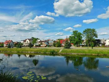 Scenic view of lake in town against sky