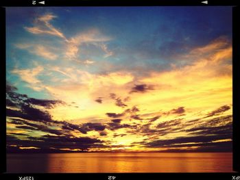 Scenic view of sea against cloudy sky at sunset