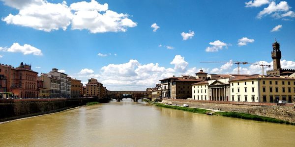 River amidst buildings in city against sky