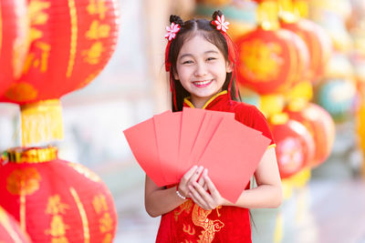 Portrait of a smiling young woman holding balloons