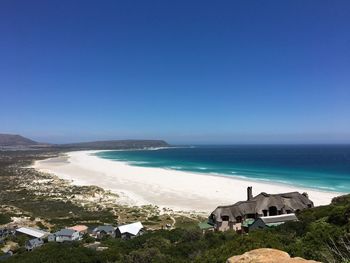 Scenic view of beach against clear blue sky