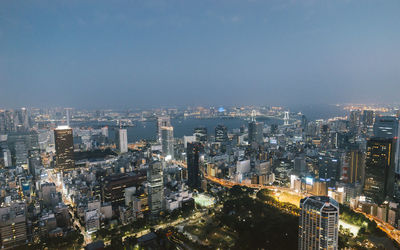 Illuminated cityscape against sky