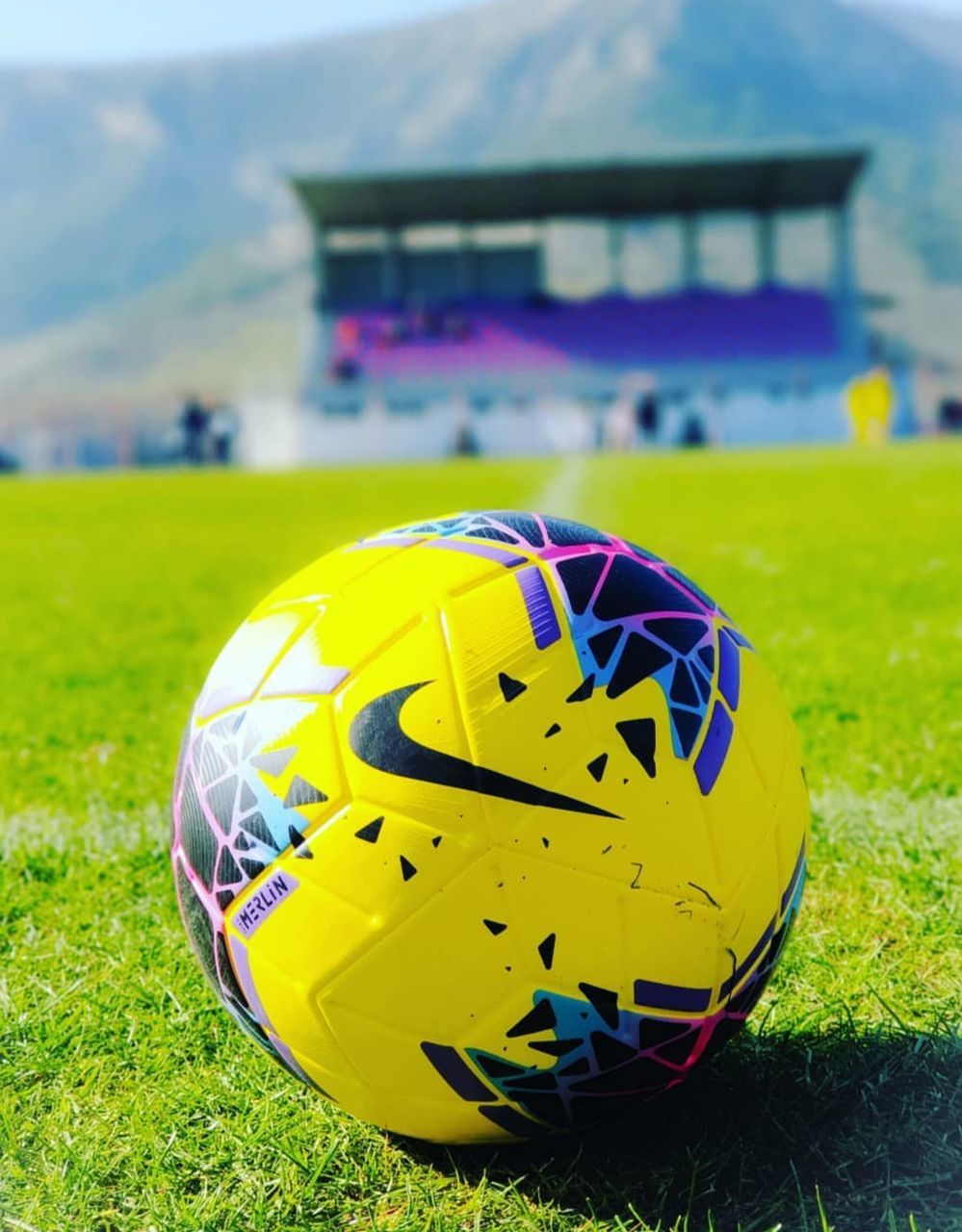 grass, ball, day, sport, plant, nature, focus on foreground, no people, field, close-up, sphere, yellow, sports equipment, land, outdoors, soccer, team sport, architecture, sunlight, inflatable