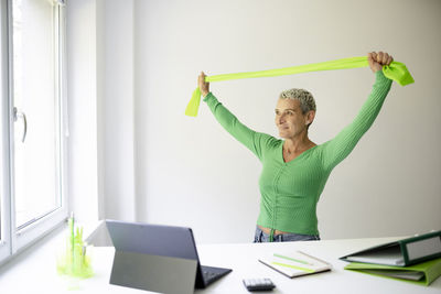 Midsection of woman using digital tablet while standing in office