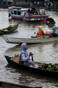 Woman selling food on boat in lake