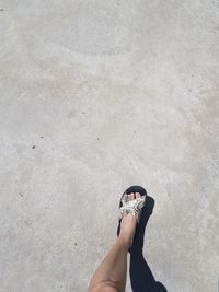 Low section of person standing on sand