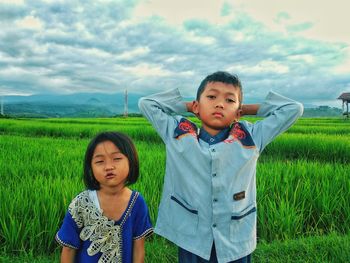 Portrait of smiling young woman standing on field and kids