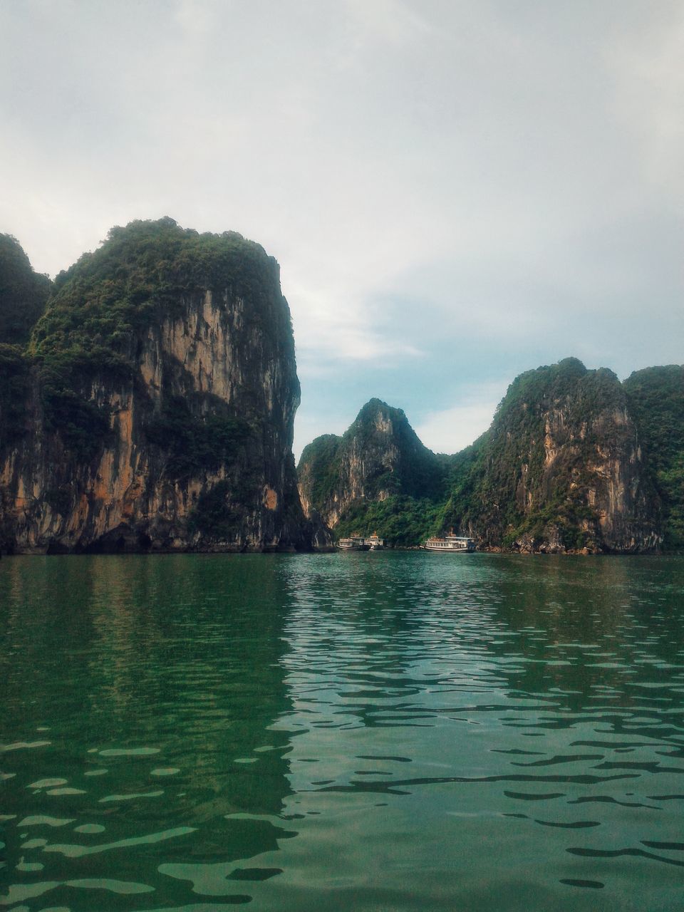 water, mountain, beauty in nature, sky, waterfront, scenics - nature, tranquility, sea, nature, tranquil scene, no people, day, outdoors, scenery, reflection, idyllic, rock, non-urban scene, formation, view into land