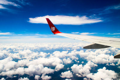 Low angle view of airplane flying against blue sky