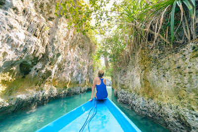 Rear view of woman on rock by swimming pool