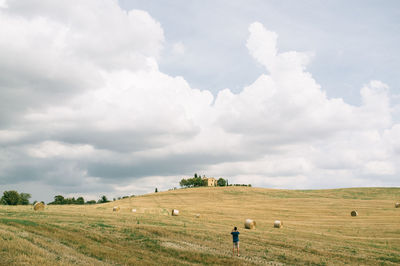 Scenic view of field against cloudy sky