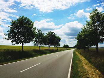 Empty road along trees