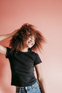 Portrait of smiling woman standing against wall