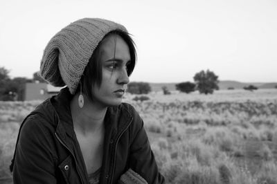 Portrait of young woman looking away on field