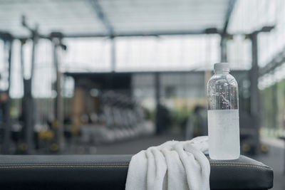 Close-up of water bottle and towel at gym