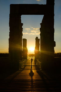 Silhouette man walking on walkway at persepolis