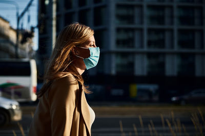 Woman in protective mask at city street