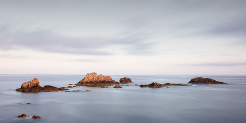 Rocks in sea against sky