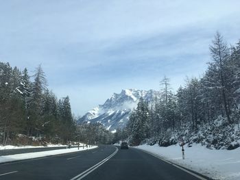 Road amidst trees against sky