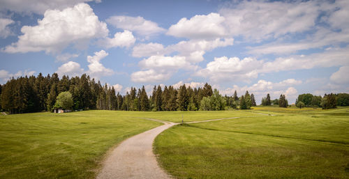 Panoramic view of golf course against sky
