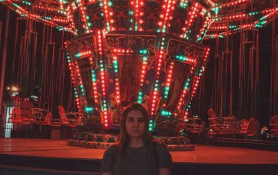 Portrait of woman in illuminated amusement park