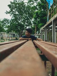 Young man sitting on footbridge