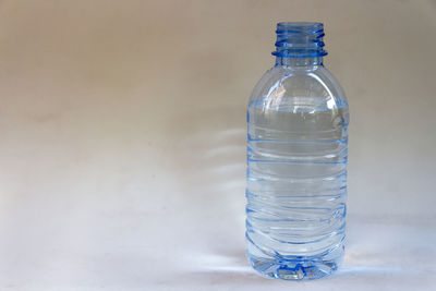 Close-up of water bottle on white table