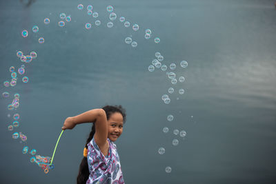 Full length of smiling boy with bubbles