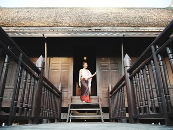 Mature woman standing on doorway