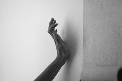 Cropped image of hand on wall