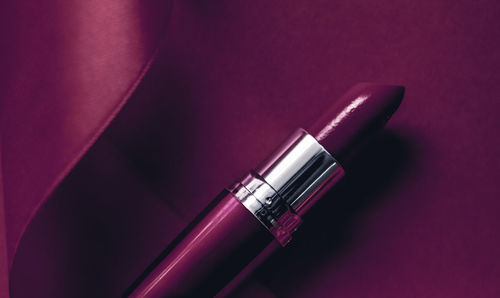 Close-up of lipstick over purple background