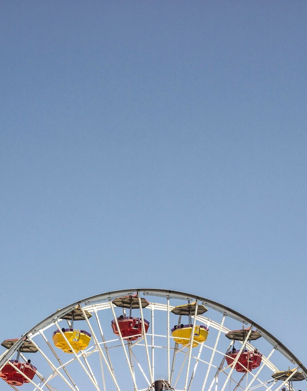 amusement park ride, amusement park, sky, ferris wheel, low angle view, copy space, clear sky, arts culture and entertainment, blue, no people, nature, architecture, built structure, day, carnival, outdoors, leisure activity, traveling carnival, metal, fairground