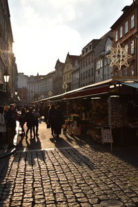 People walking on street in city against sky