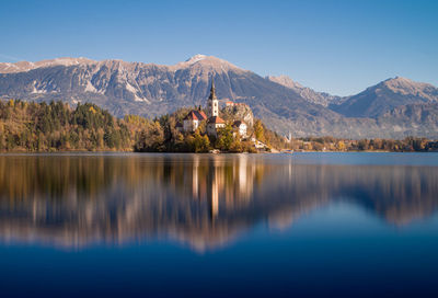 Scenic view of lake and mountains against blue sky