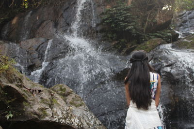 Rear view of woman looking at waterfall