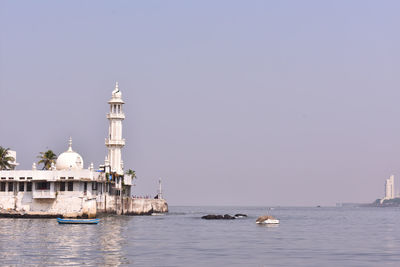 View of buildings in sea against clear sky