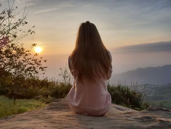 Rear view of woman looking at sunset