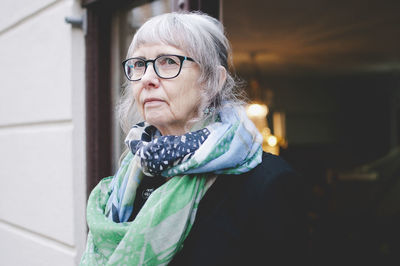 Thoughtful female craftsperson wearing scarf while standing outside jewelry shop